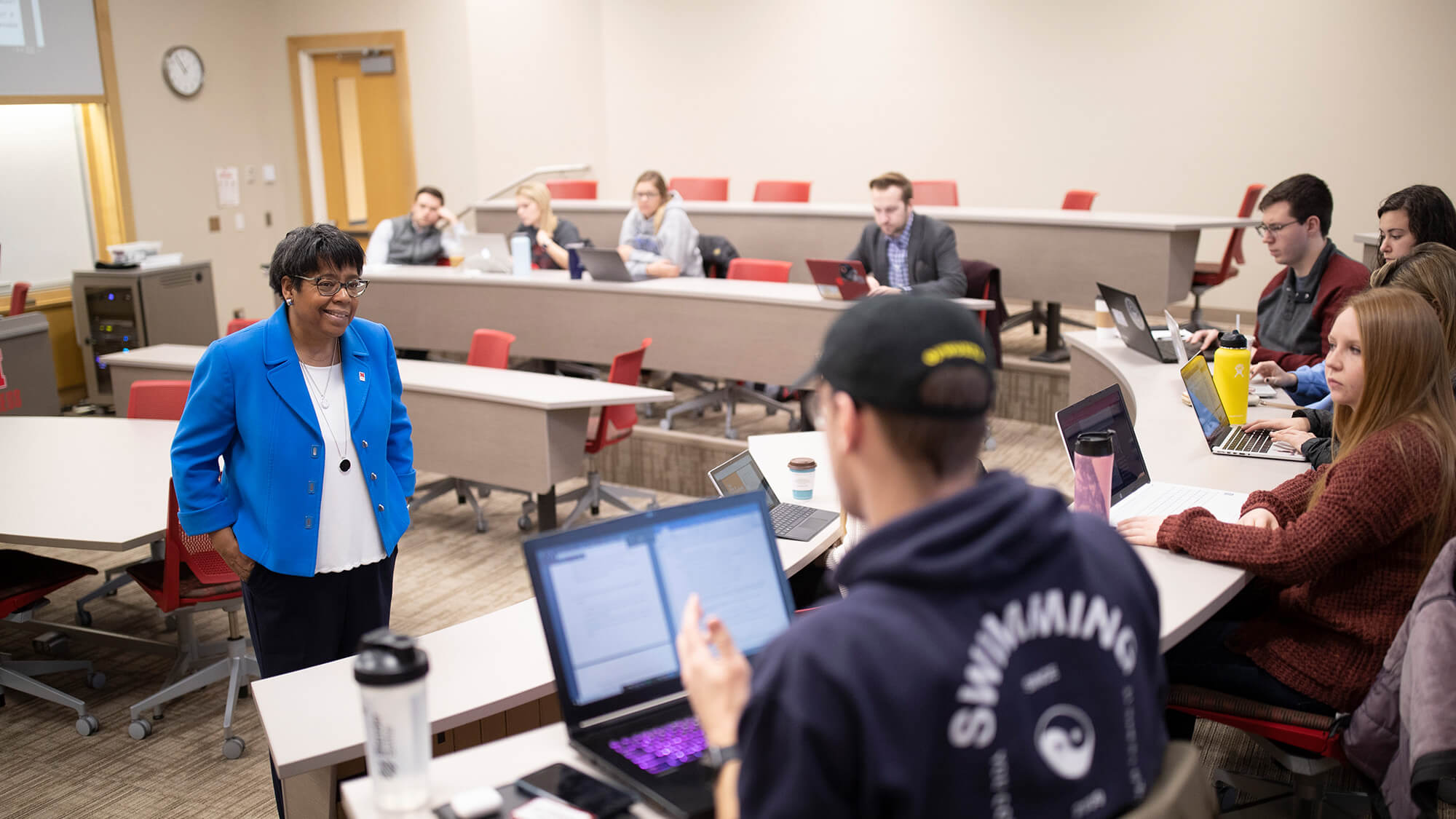 Faculty member talks to students in classroom