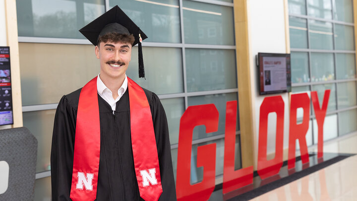 Ethan Zaborowski in his cap and gown in Hawks Hall