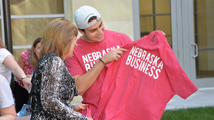 Dean Kathy Farrell checking out Nebraska Business T-shirts at the Traditions Tailgate.