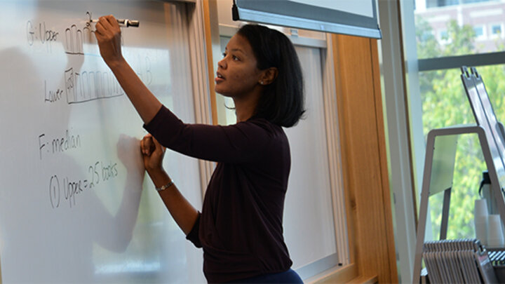 Woman writing on whiteboard