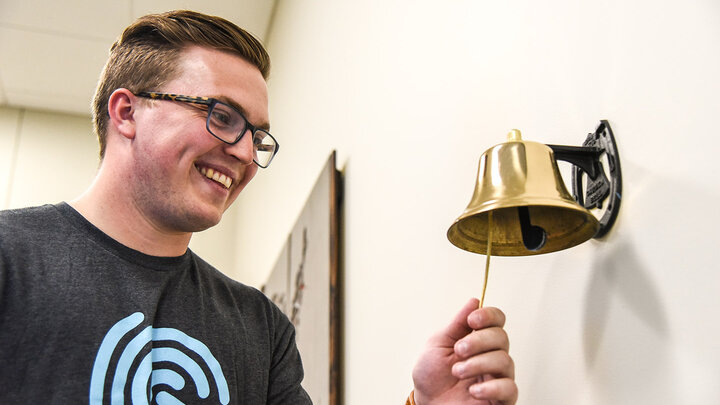 Hunter Kelley, ’19, rings the 'Success Bell' indicating a job offer from Spreetail.
