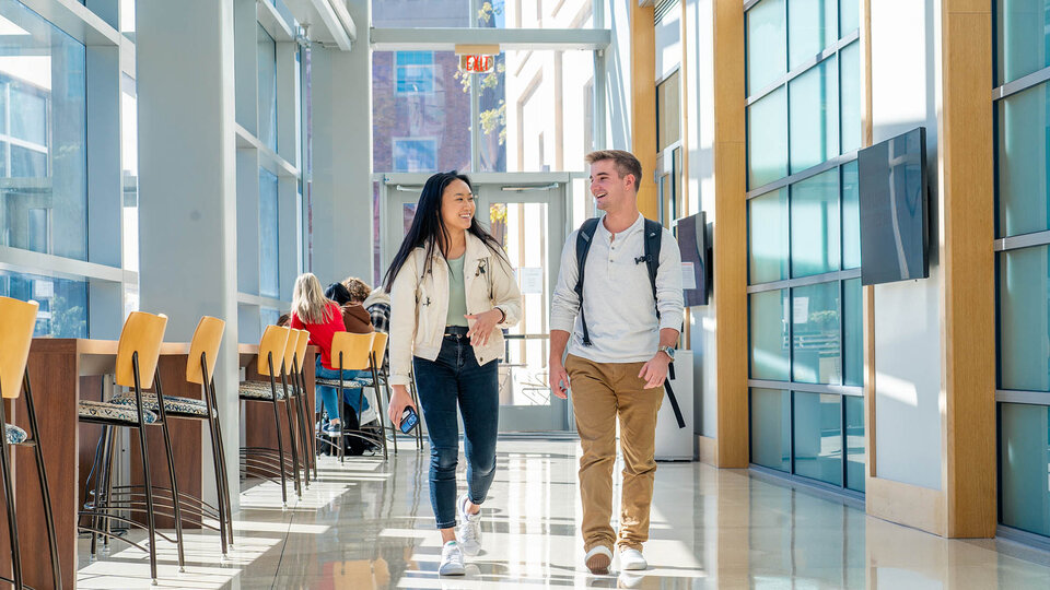 students walking in Hawks Hall