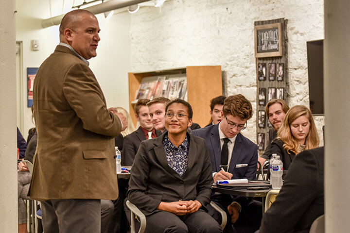 Logans listens intently to Josh Brewster while on a site visit at Trozzolo, an advertising agency.