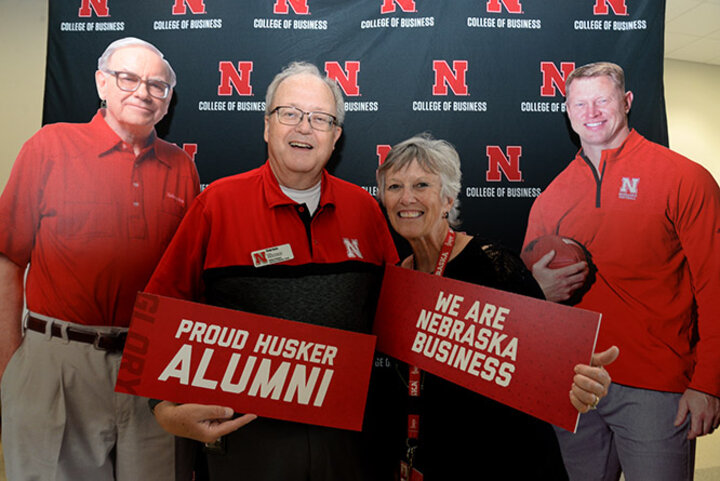 Dr. D’vee Buss, assistant dean of undergraduate programs, poses with Clyde Davis, lecturer of supply chain management and analytics, along with life-size cutouts of Buffett and his favorite active football coach and finance alumnus Scott Frost at the Back to School Bash.