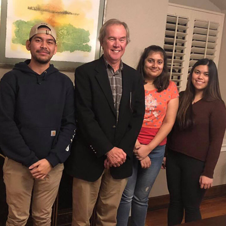 Dr. Dennis Duchon with international students during the Thanksgiving festivities, which included some musical interludes on the piano.