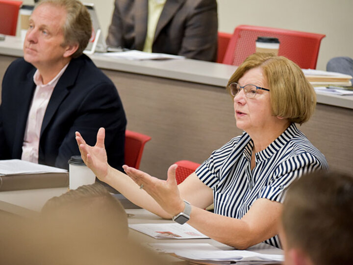 Joann Martin, ’75, engages with students presenting their solutions to challenges Ameritas faces.
